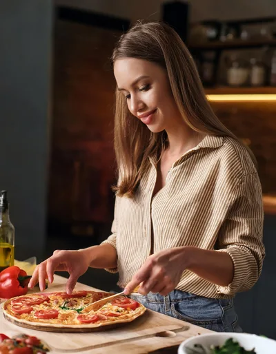 Young Woman Preparing Homemade Pizza In Kitchen