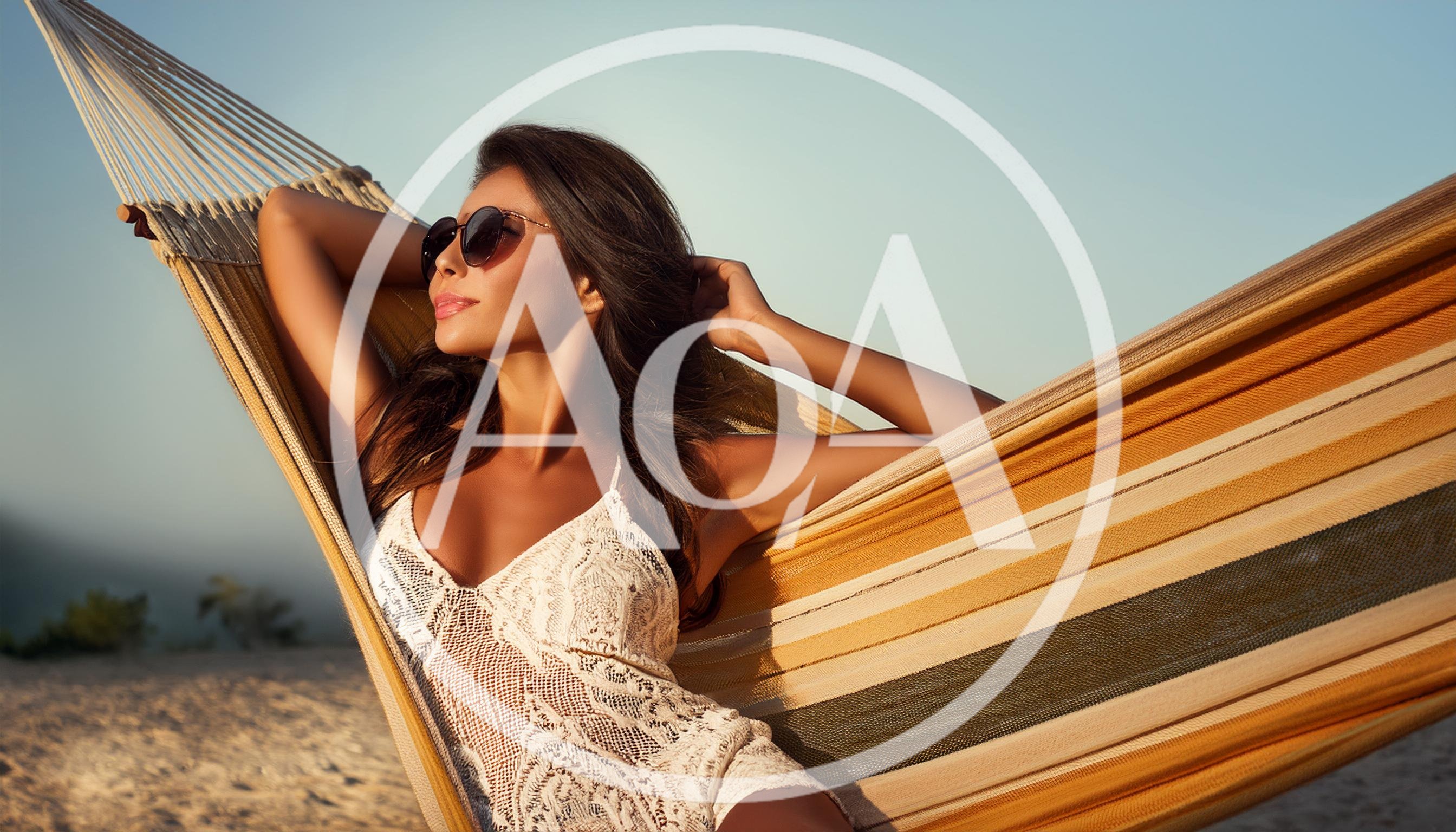 Beautiful Woman Relaxing In A Hammock On The Beach