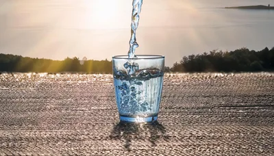 Water Pouring Into A Glass At Sunset