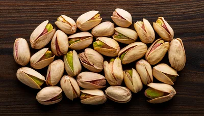 Top View Of Roasted Pistachios On Dark Wooden Surface