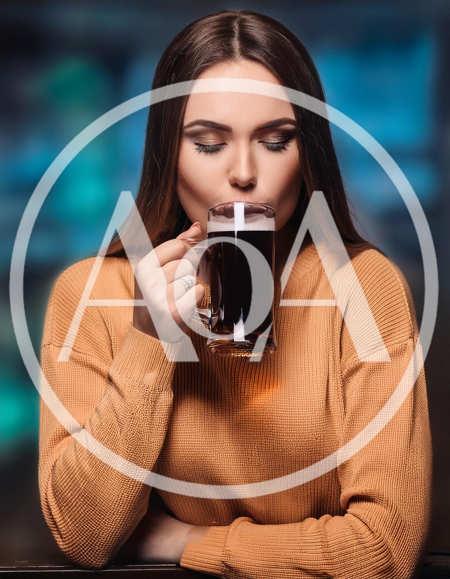 Young Woman Drinking Dark Beer From A Glass Mug