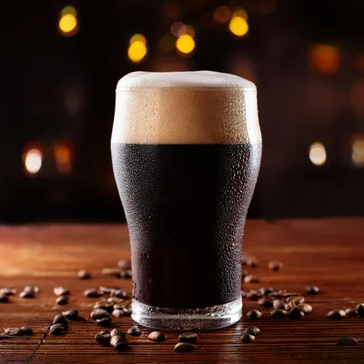 Cold Glass Of Dark Stout Beer With Coffee Beans