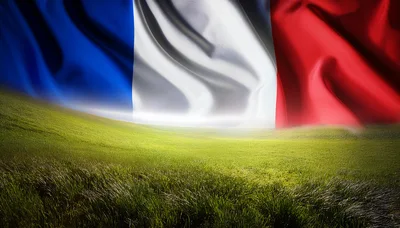 French Flag Waving Over A Lush Green Field