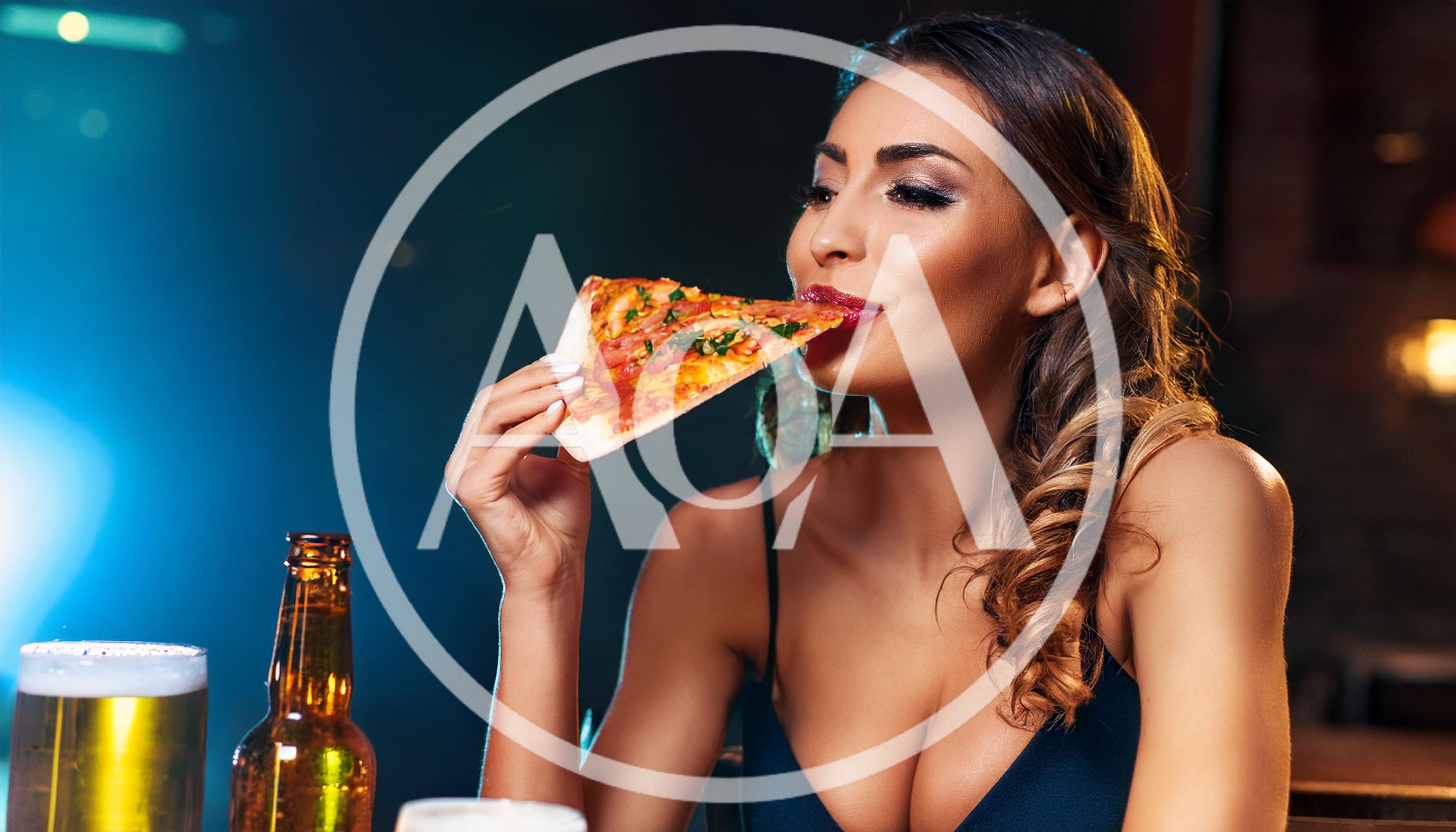 Beautiful Woman Eating Pizza Slice in a Bar