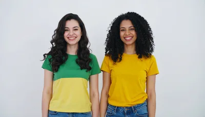 Two Diverse Women Smiling Together Against White Background