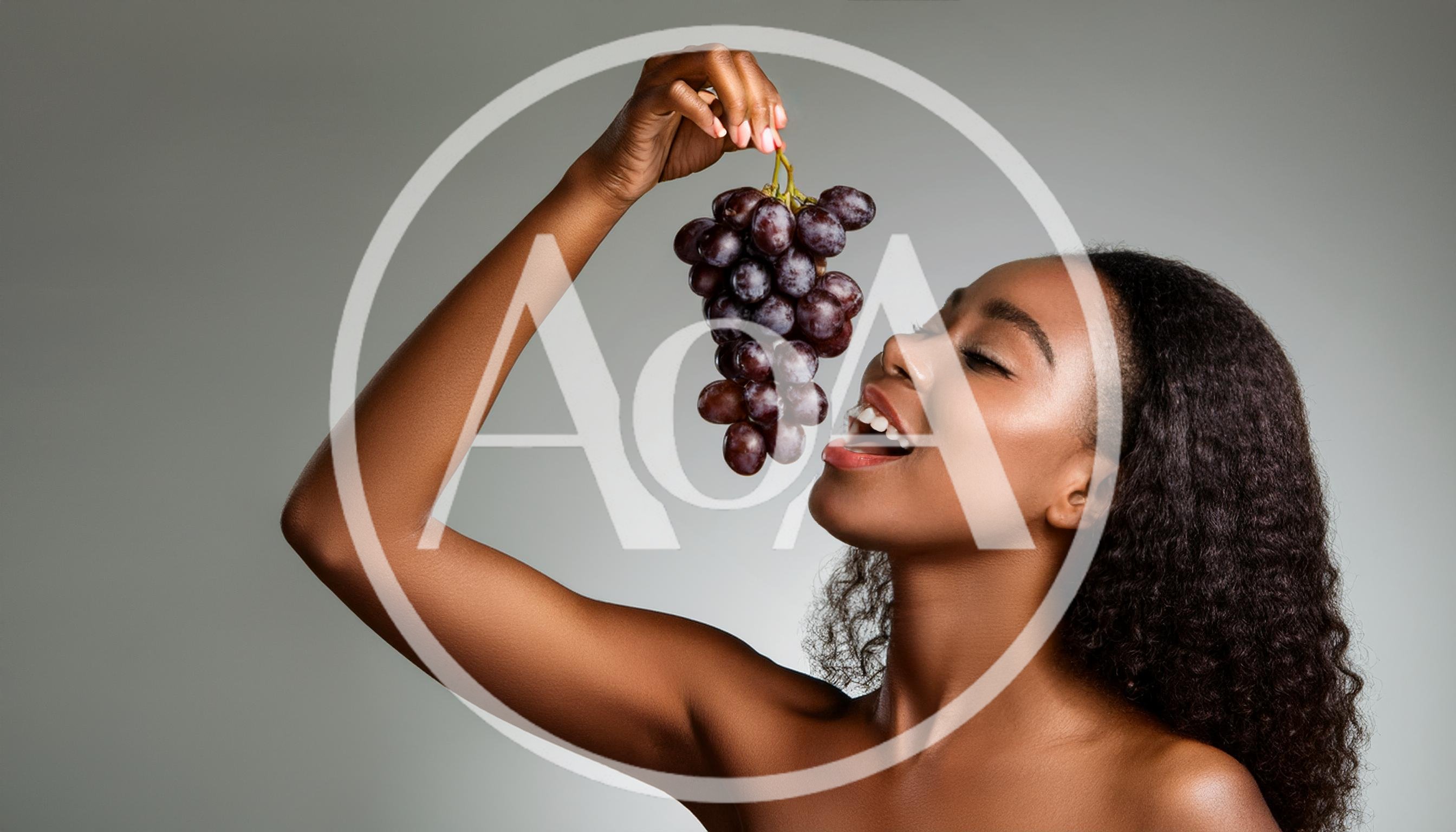 Young Woman Holding And Eating Fresh Purple Grapes