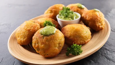 Fried Potato Balls With Green Sauce On Wooden Plate
