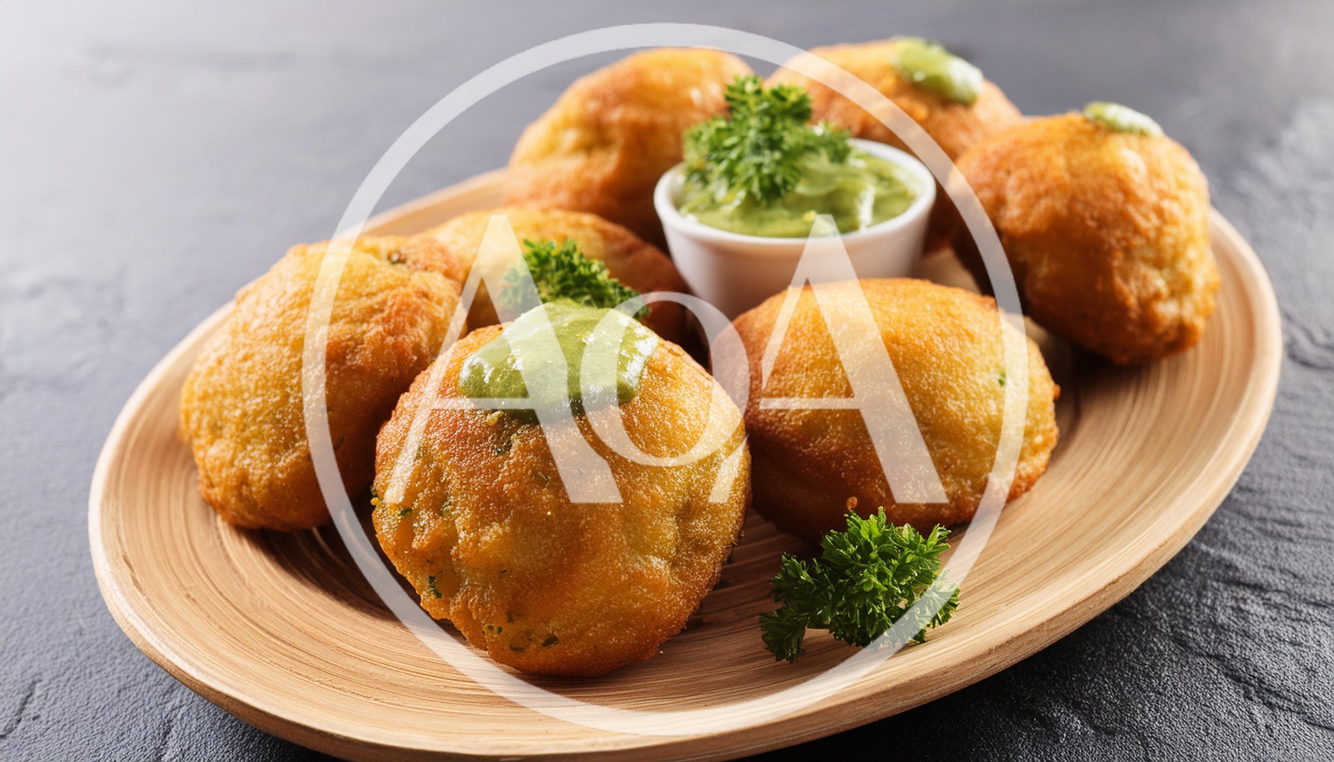 Fried Potato Balls With Green Sauce On Wooden Plate