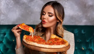 Beautiful Woman Eating Pizza In A Restaurant