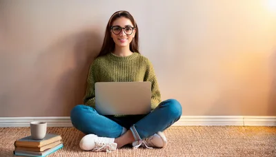 Young Woman Sitting On Floor Using Laptop