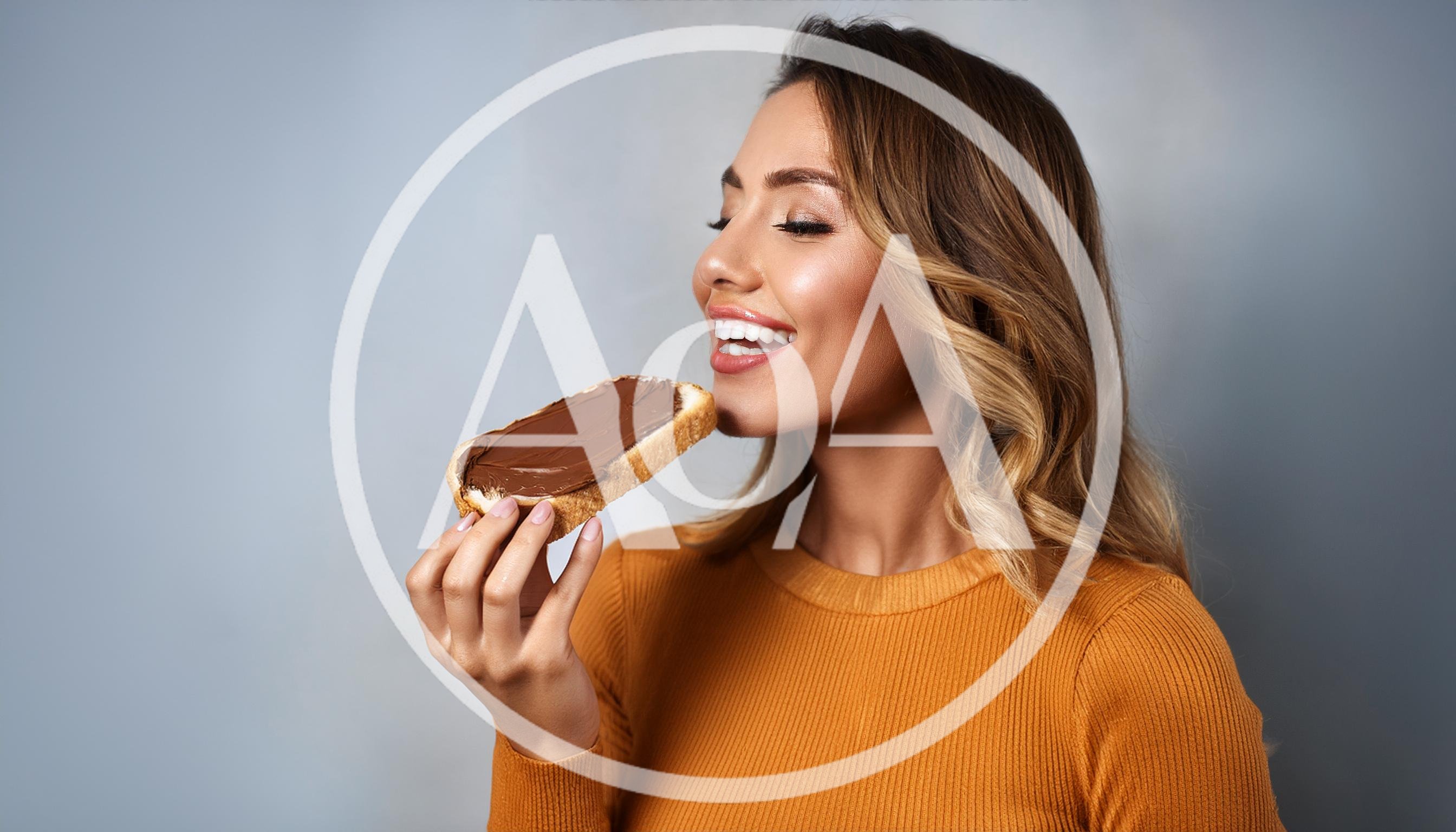 Young Woman Enjoying A Slice Of Chocolate Spread Toast