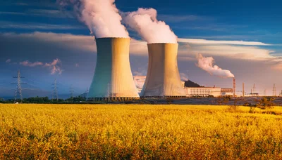 Nuclear Power Plant Cooling Towers Above Yellow Rapeseed Field