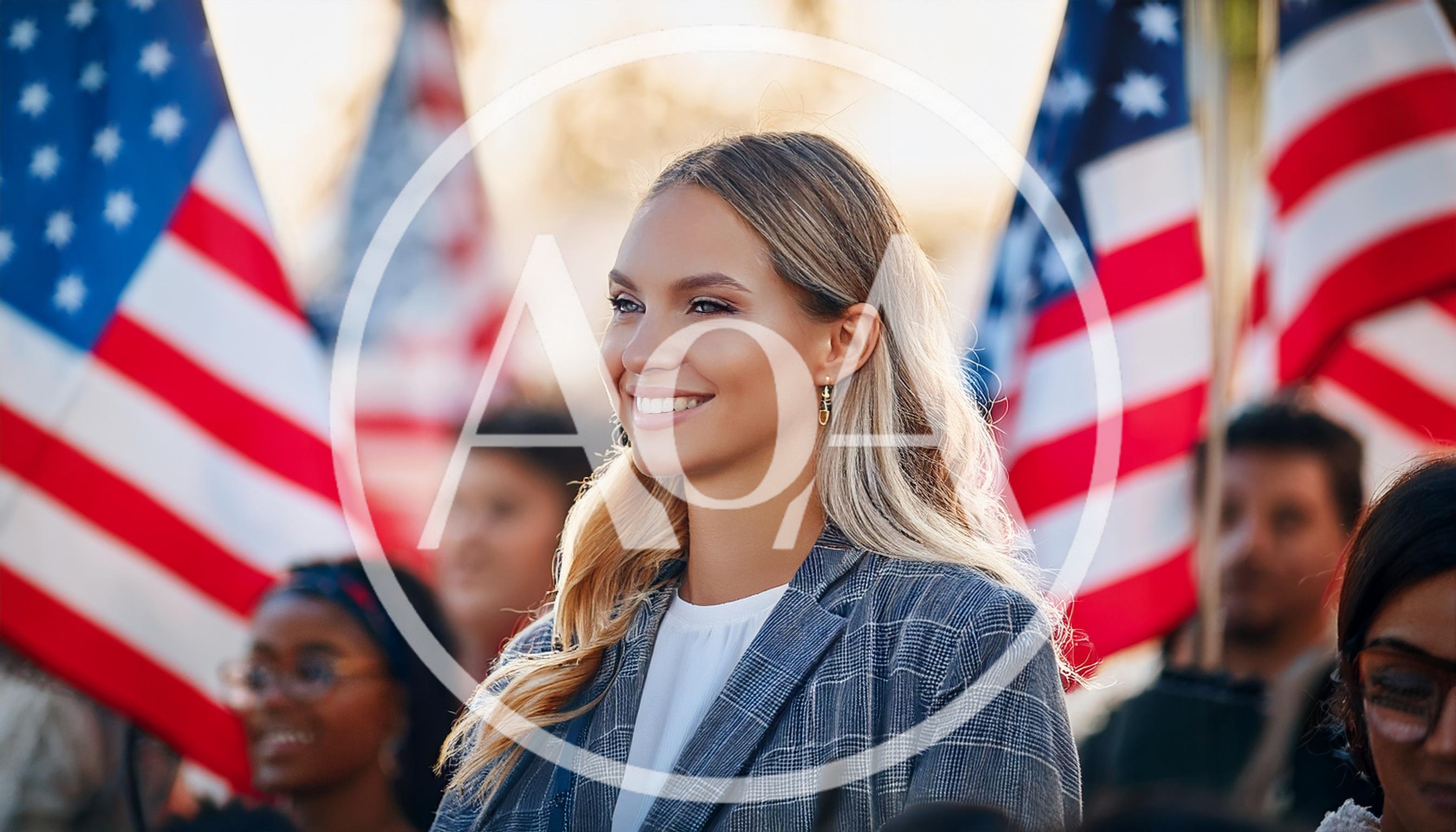 Smiling Young Woman Standing Before American Flags