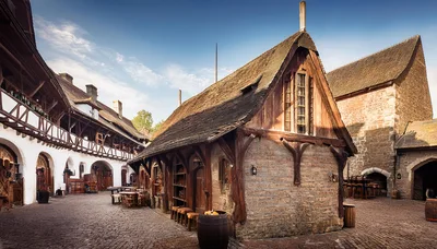 Medieval Tavern Courtyard With Stone Buildings And Wooden Architecture