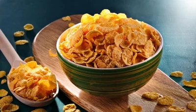 Bowl Of Crunchy Cornflakes On A Wooden Board