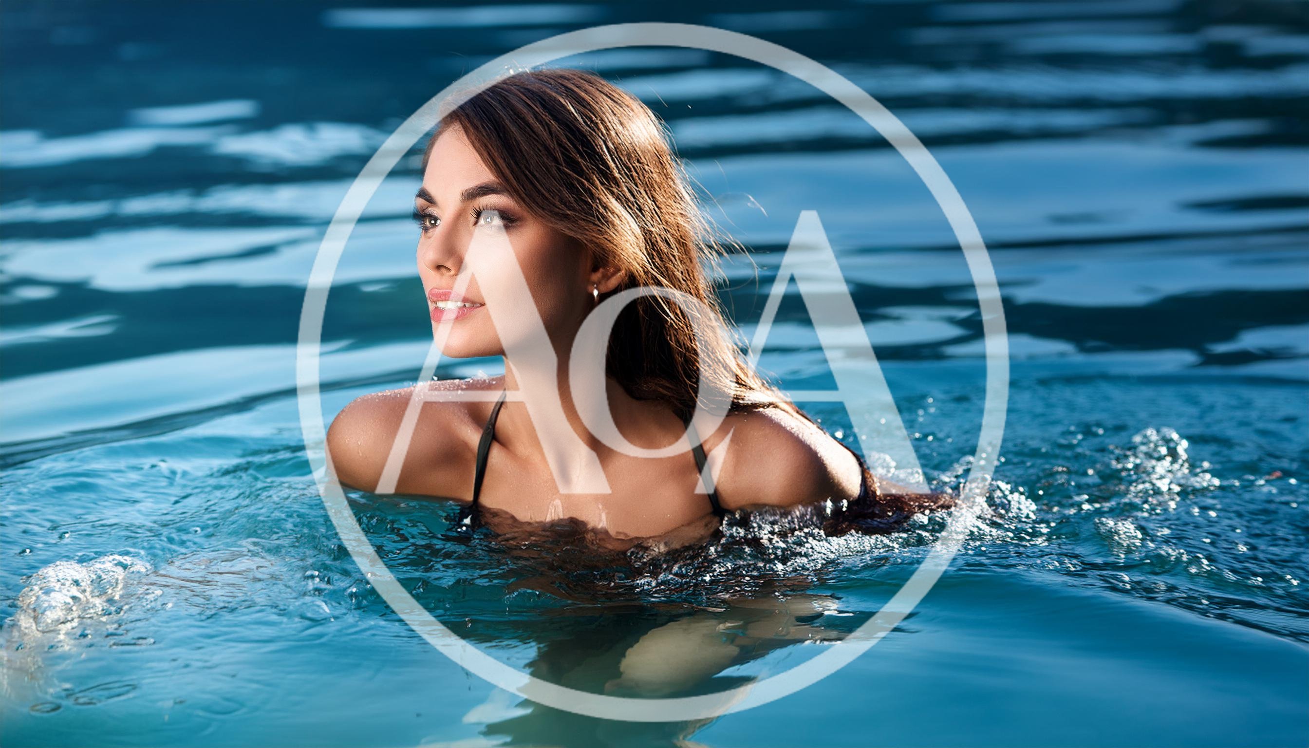 Beautiful Woman Swimming In A Clear Blue Pool