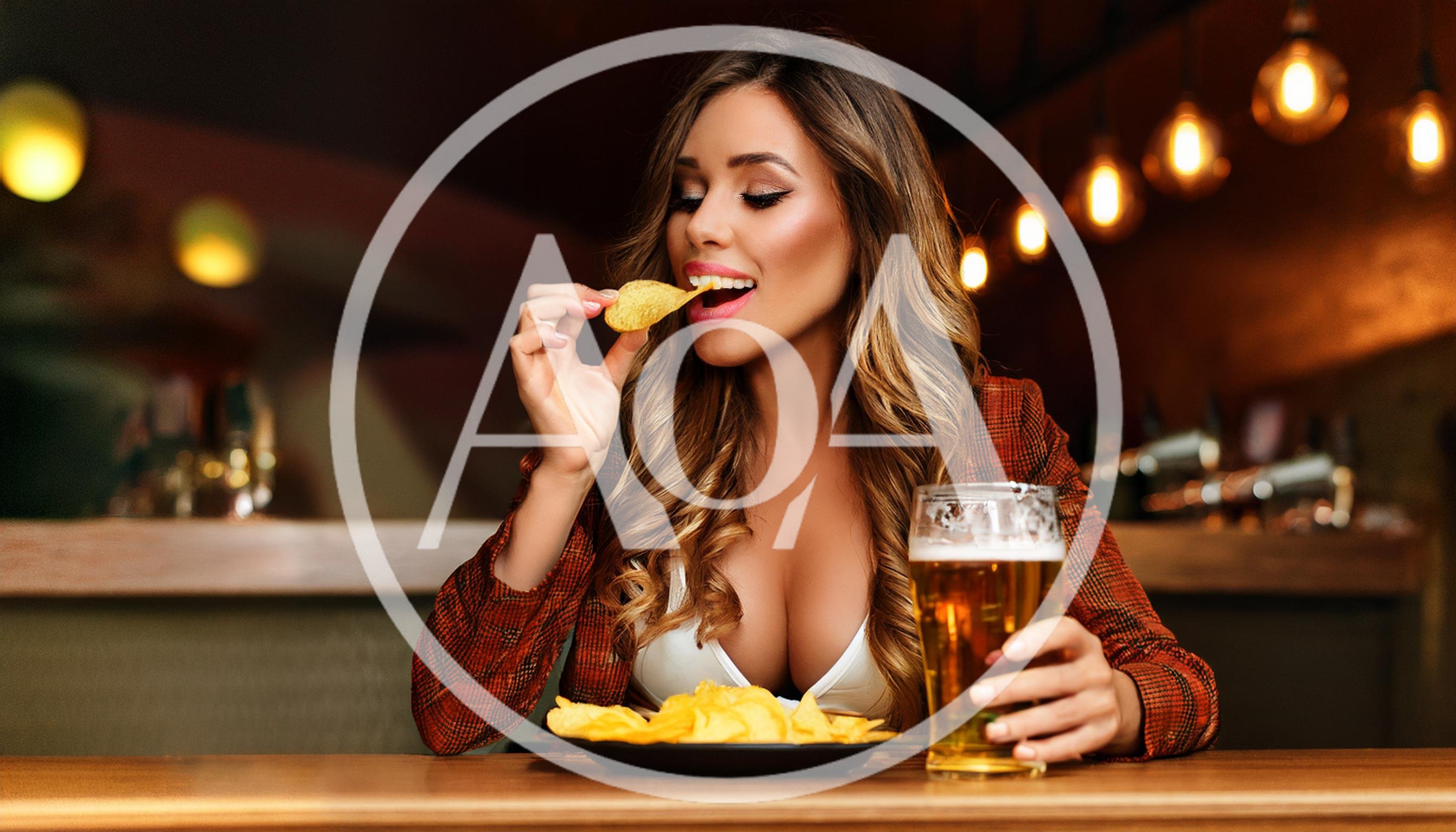 Attractive Woman Eating Potato Chips and Drinking Beer
