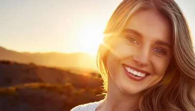 Smiling Young Woman Enjoying Golden Hour Sunset
