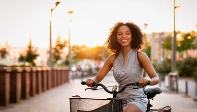 Young Woman Riding A Bicycle At Sunset