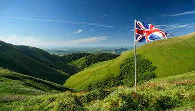 British Flag Flying Over Rolling Green Hills