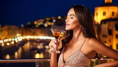 Elegant Woman Holding Martini Glass On Night Balcony