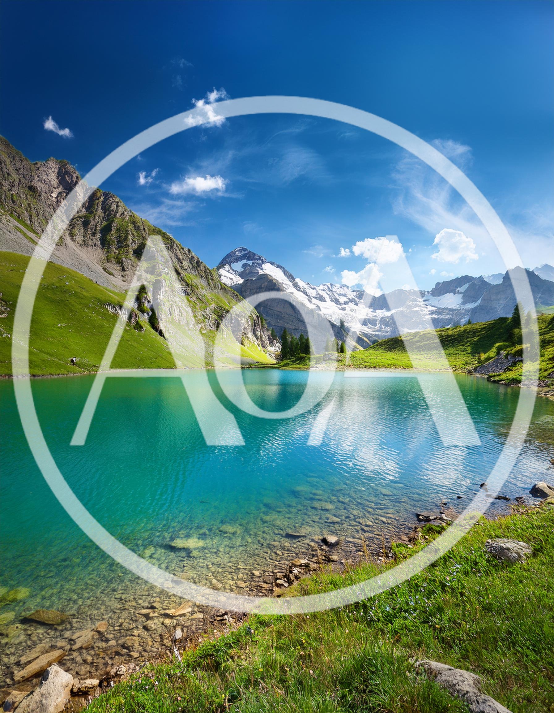 Alpine Lake With Snow Capped Mountains In Switzerland