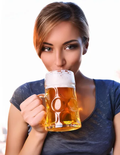 Young Woman Drinking Beer From A Glass Mug