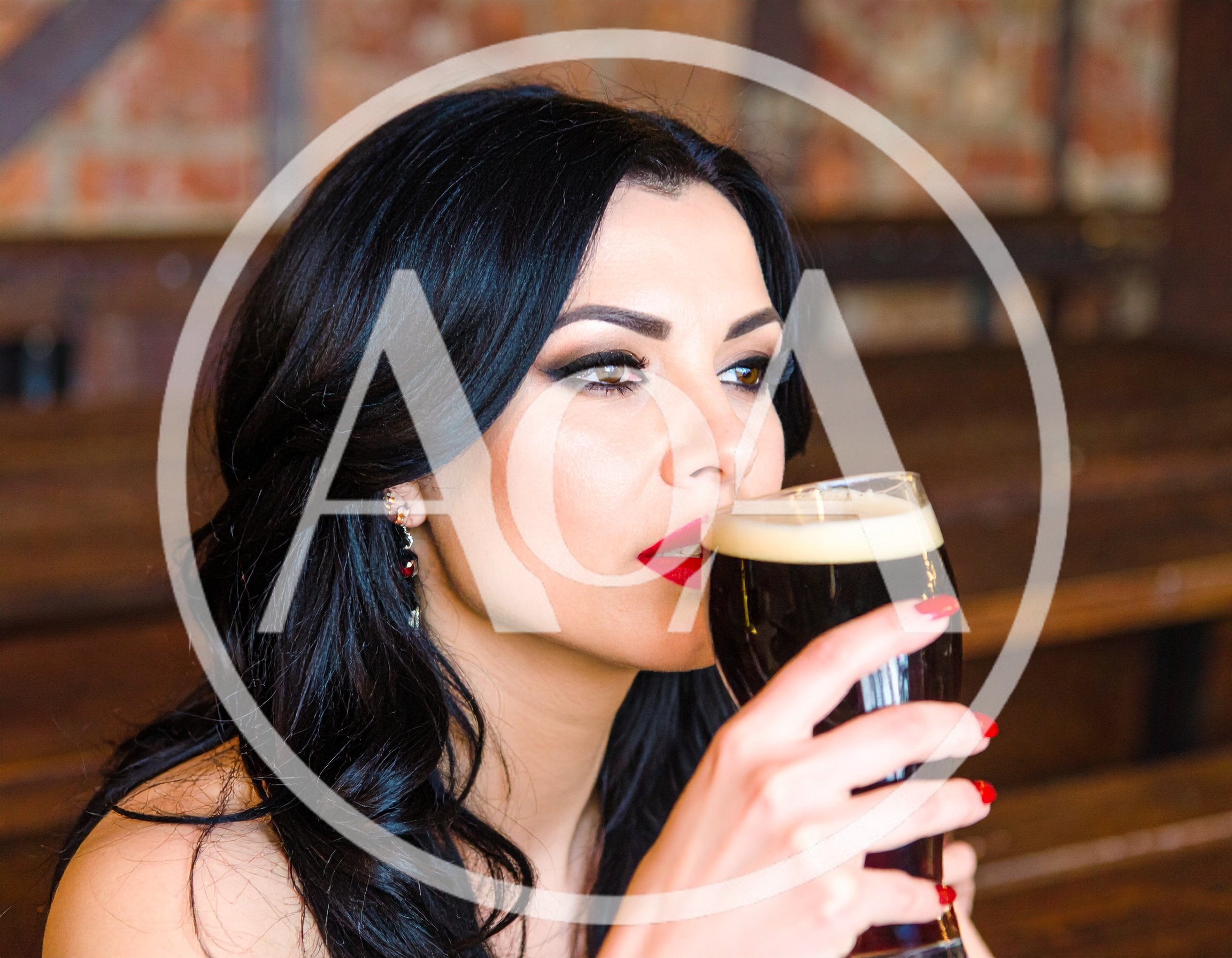 Beautiful Woman Drinking Dark Beer in a Pub