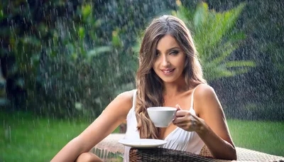 Young Woman Drinking Coffee During A Rain Shower