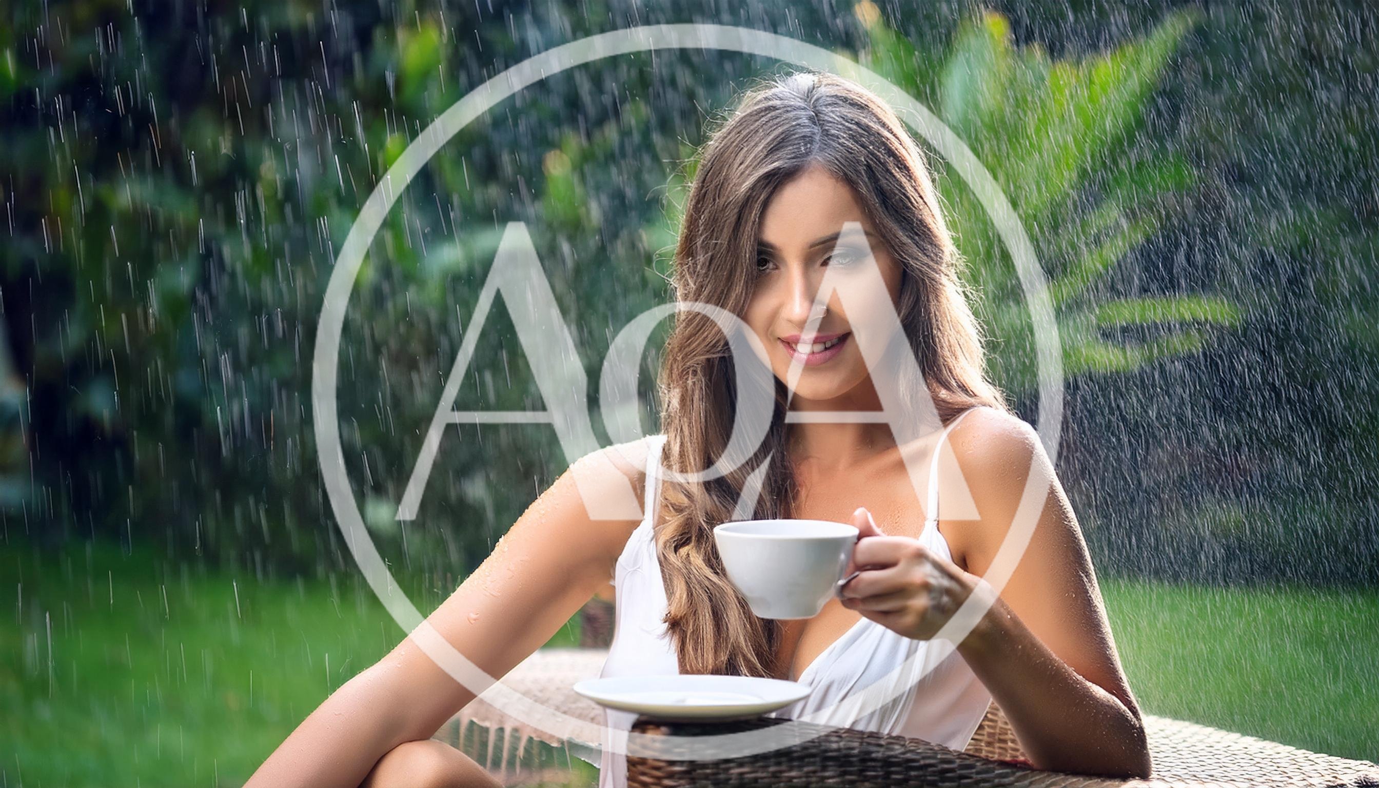 Young Woman Drinking Coffee During A Rain Shower
