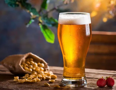 Glass Of Golden Beer With Peanuts And Strawberries