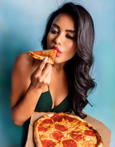 Young Woman Eating Pepperoni Pizza Slice