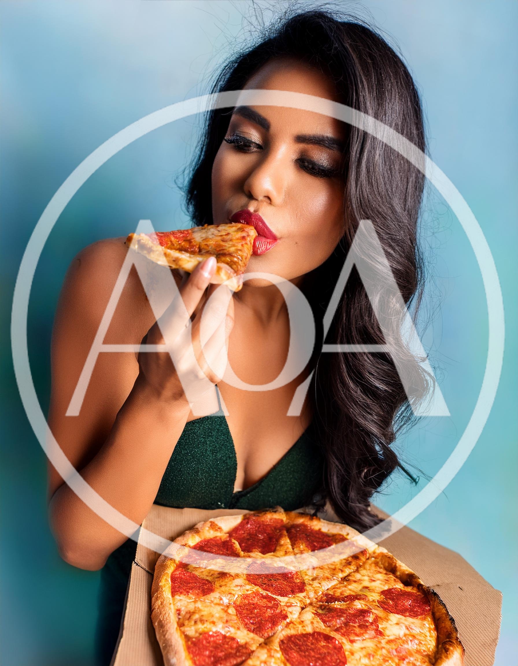 Young Woman Eating Pepperoni Pizza Slice