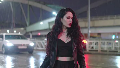 Stylish Woman Walking Through Rainy City Street At Night
