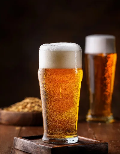 Two Glasses Of Golden Beer On A Wooden Table