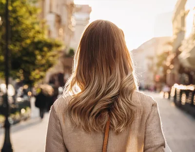 Woman With Blonde Hair Walking Down City Street