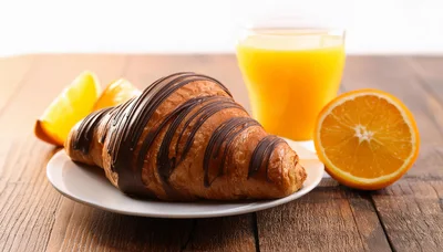 Chocolate Drizzled Croissant With Orange Juice And Slices