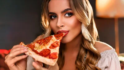 Beautiful Woman Eating A Slice Of Pepperoni Pizza