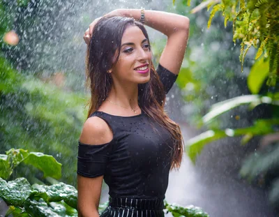 Young Woman Posing Under Tropical Waterfall Rain