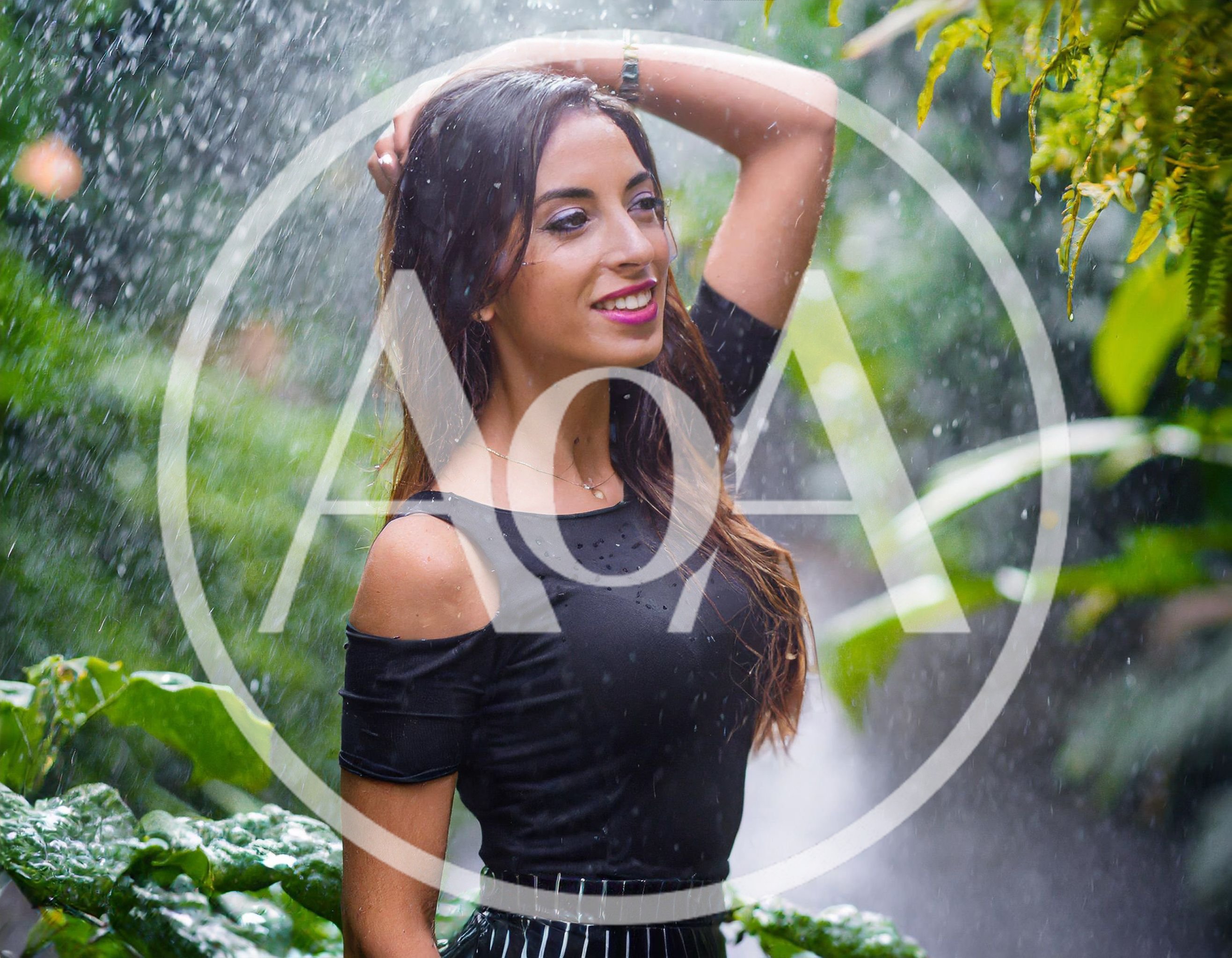 Young Woman Posing Under Tropical Waterfall Rain