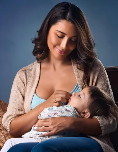 Mother Holding Her Sleeping Toddler In A Cozy Setting