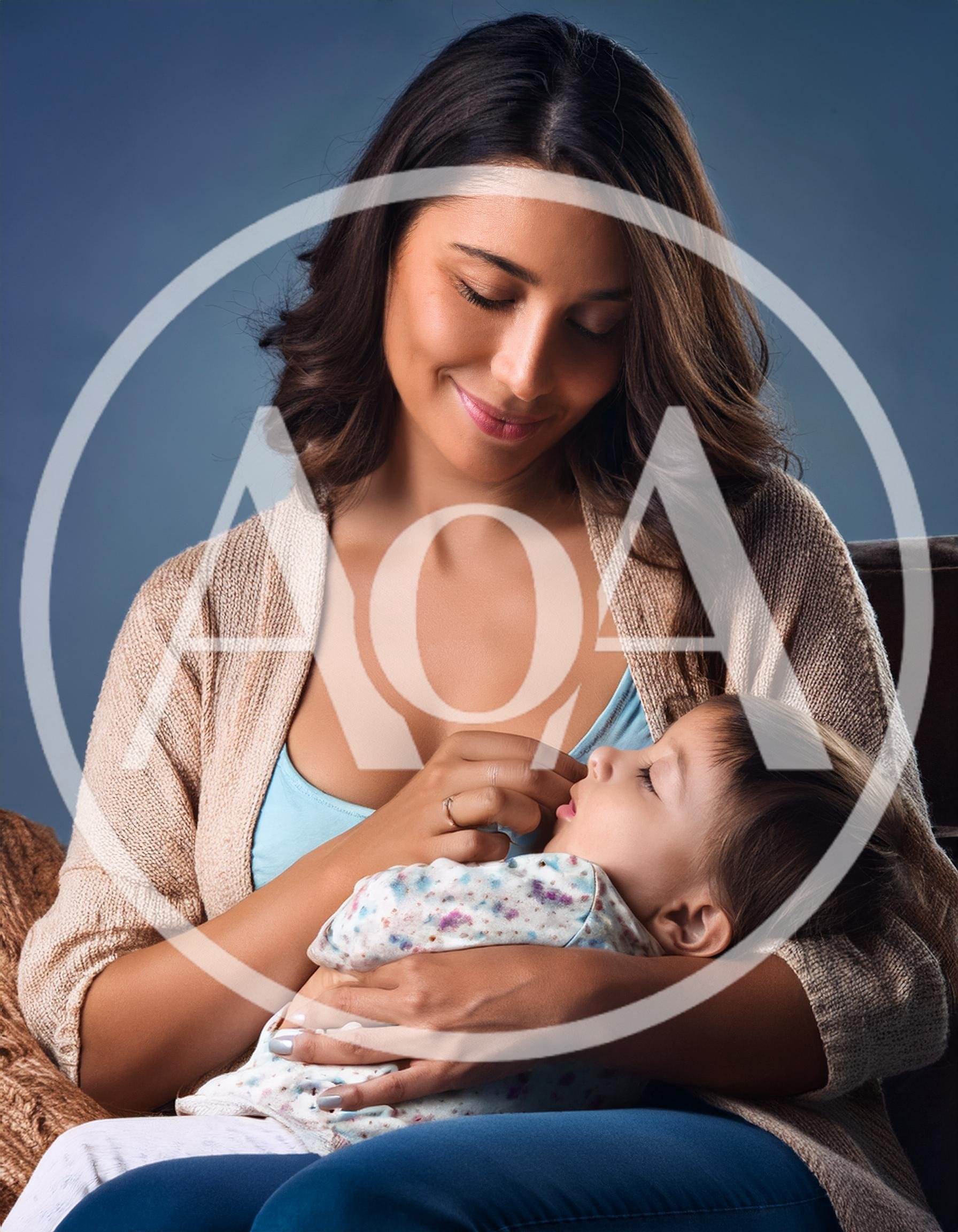 Mother Holding Her Sleeping Toddler In A Cozy Setting