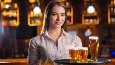 Smiling Waitress Holding A Tray Of Beer Glasses