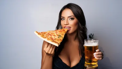 Beautiful Woman Eating Pizza Slice And Holding Beer Glass