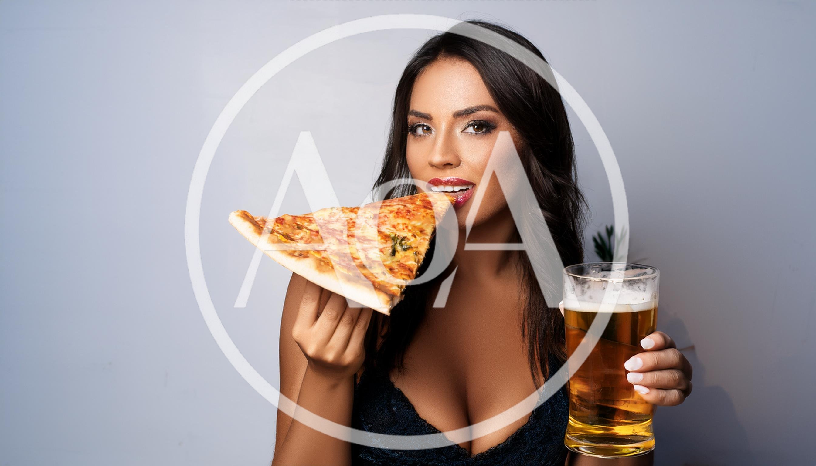 Beautiful Woman Eating Pizza Slice And Holding Beer Glass