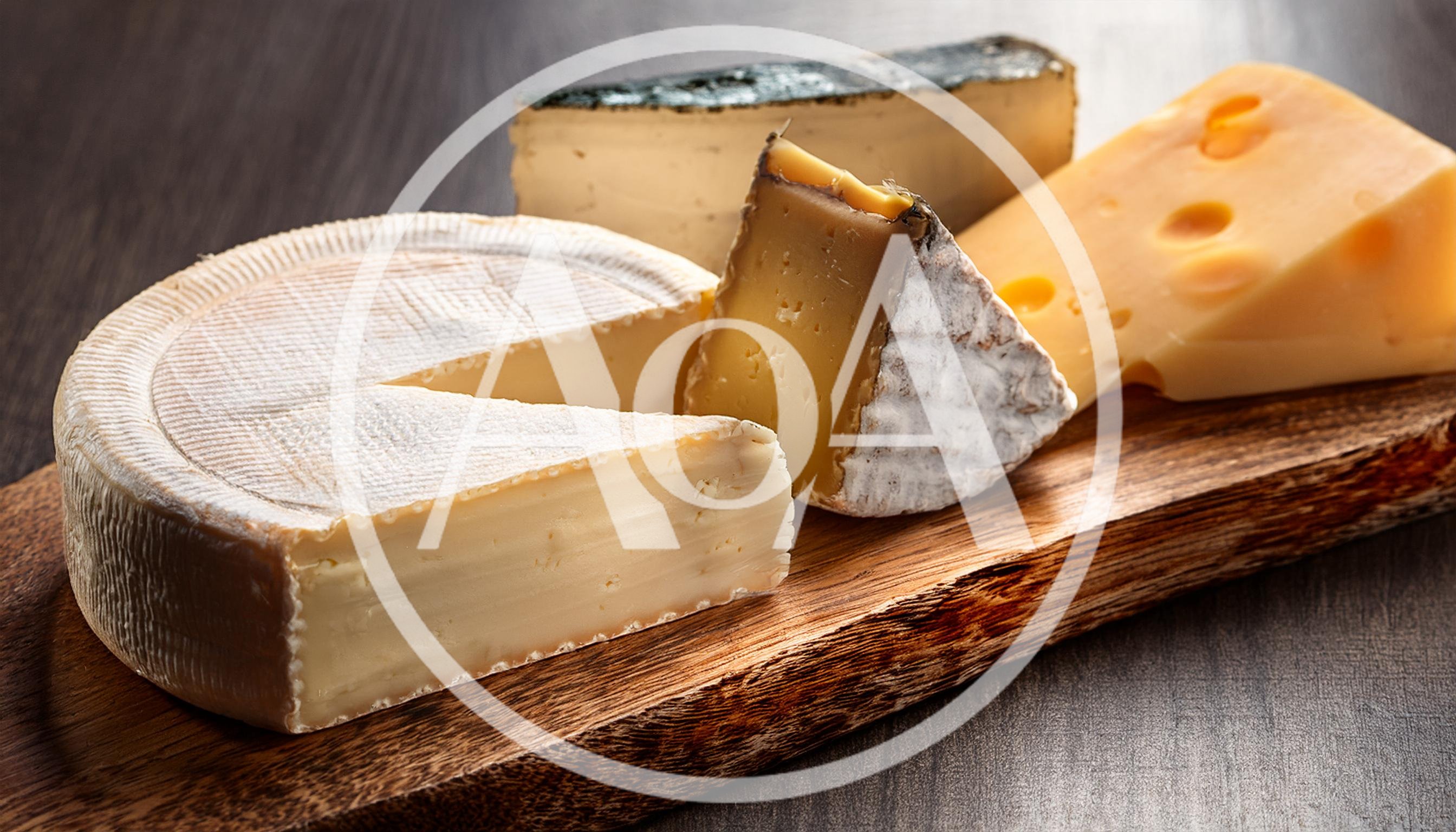 Assorted Gourmet Cheeses Arranged On A Wooden Serving Board