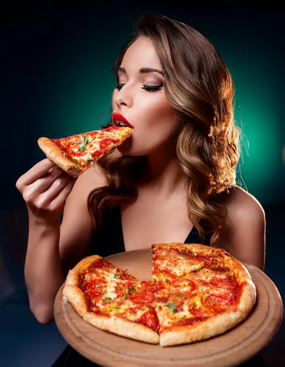 Beautiful Woman Eating A Slice Of Fresh Pizza