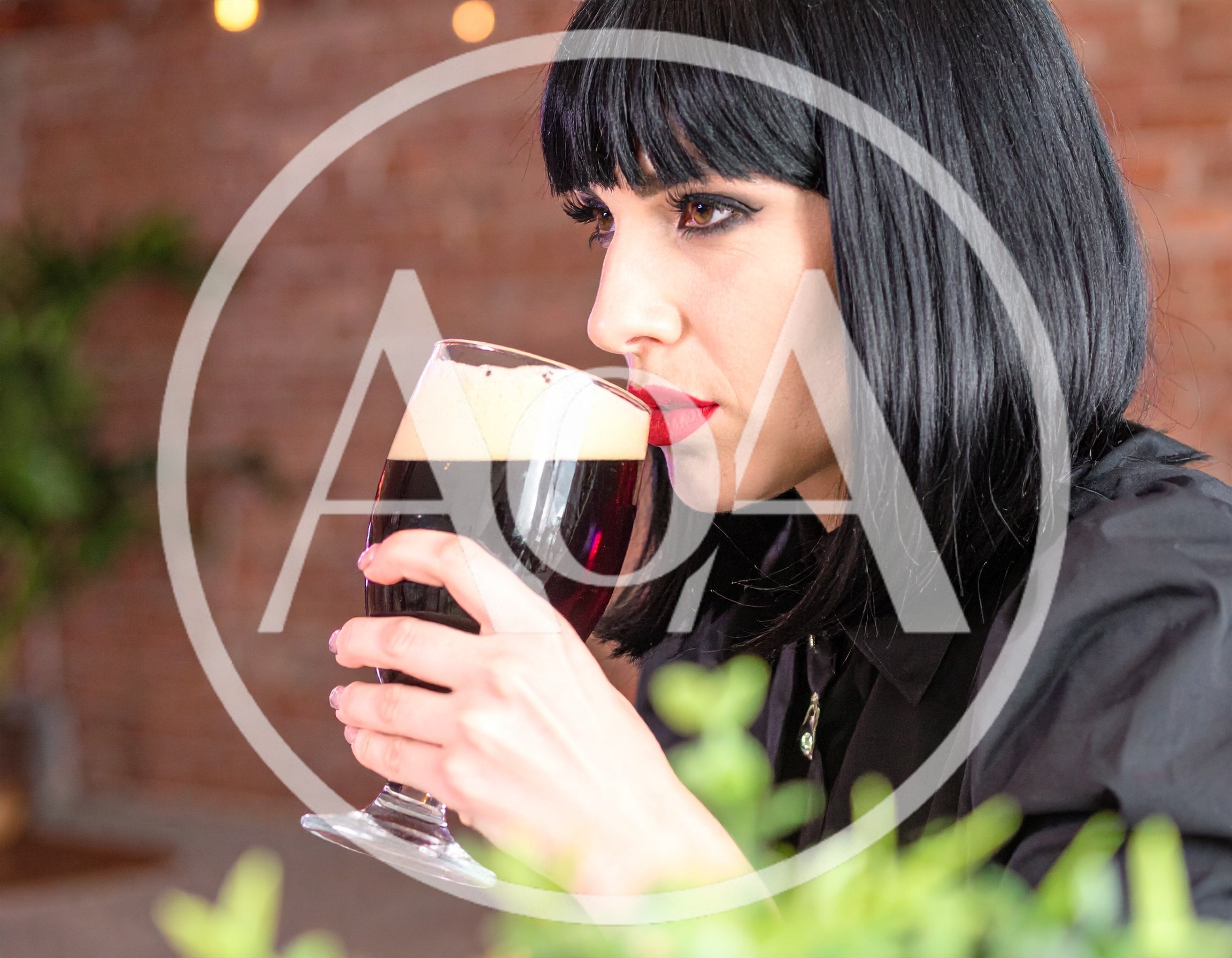 Woman With Dark Hair Drinking Dark Beer