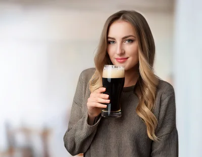 Young Woman Holding A Glass Of Dark Beer