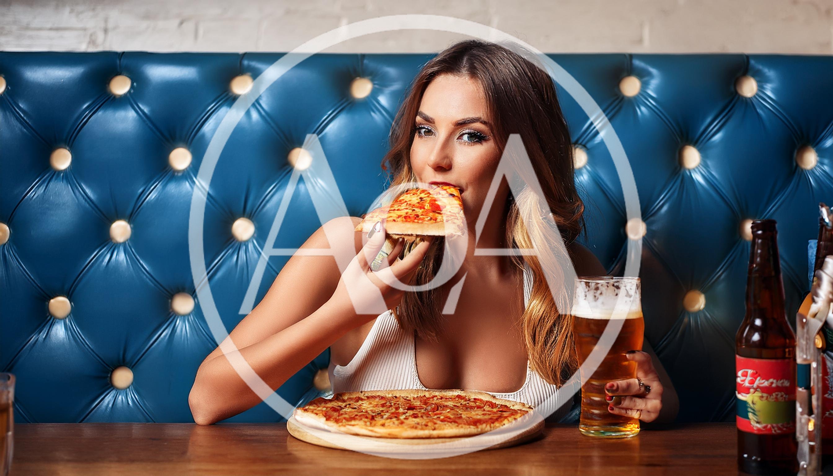 Young Woman Eating Pizza and Drinking Beer